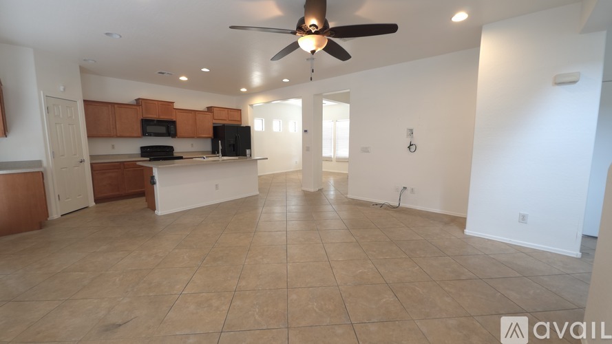 A spacious living room with a kitchen area in the background.
