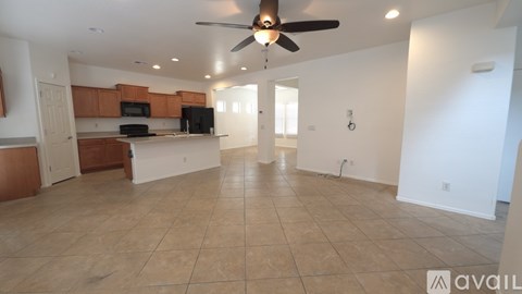 A spacious living room with a kitchen area in the background.