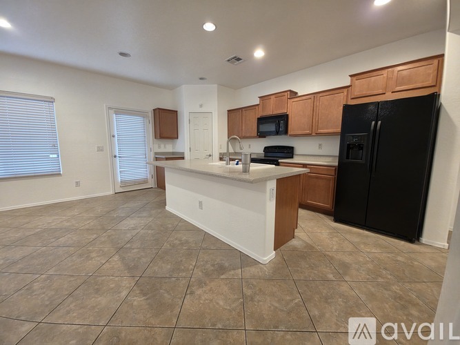 A kitchen with black appliances and wooden cabinets.