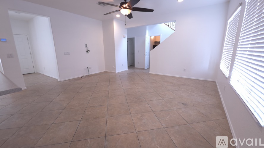 A spacious room with a ceiling fan and tiled flooring.