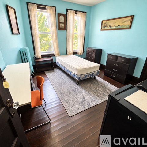 A bedroom with a bed, dresser, and chair.