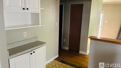 A kitchen with white cabinets and a counter top.