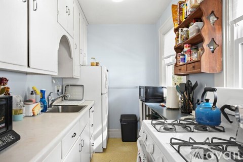 A small kitchen with a white fridge and a white stove top.