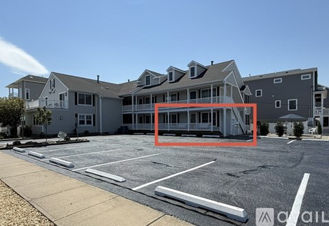 A parking lot with a building in the background and a red box around the middle of the image.