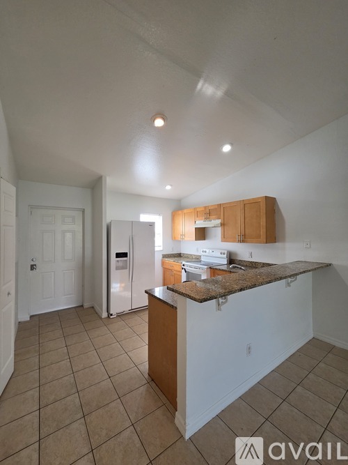 A kitchen with a white fridge and wooden cabinets.