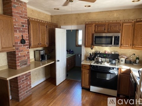 A kitchen with wooden cabinets and a brick wall.