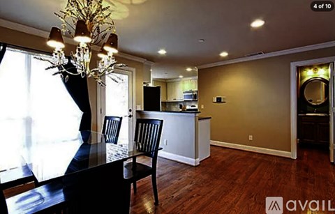 A dining room with a black table and chairs and a chandelier.
