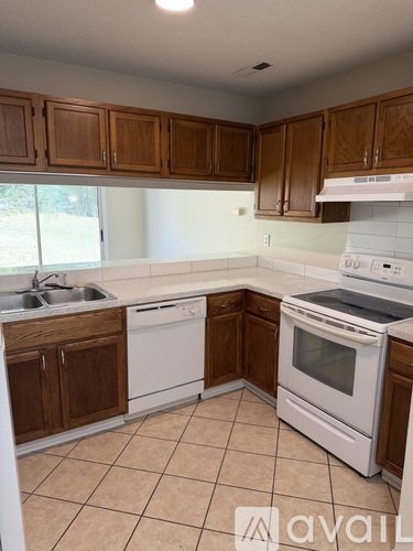 A kitchen with wooden cabinets and white appliances.