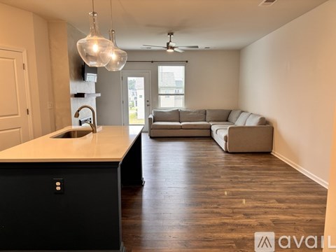 A kitchen with a black counter and a white sink.