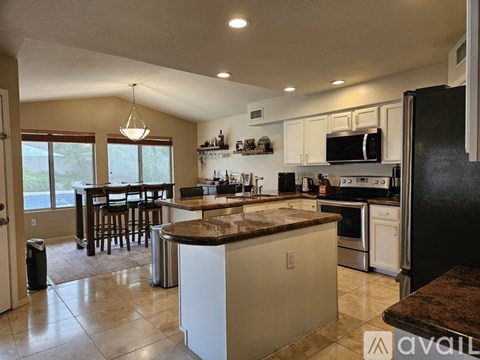 A kitchen with white cabinets and a brown island.