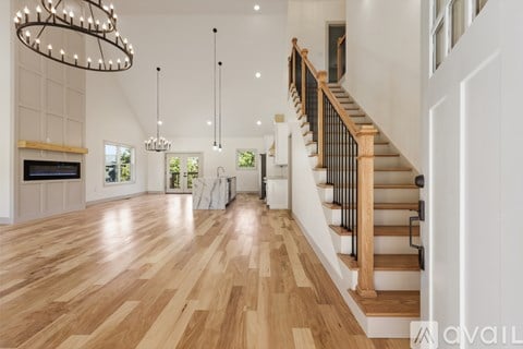 A spacious living room with a staircase leading to the upper floor.