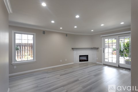 A spacious living room with a fireplace and sliding glass doors.
