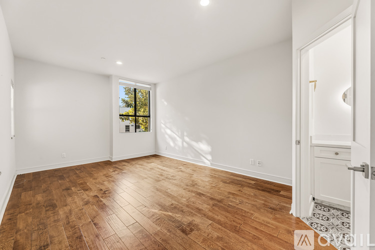 A room with wooden flooring and a white door.