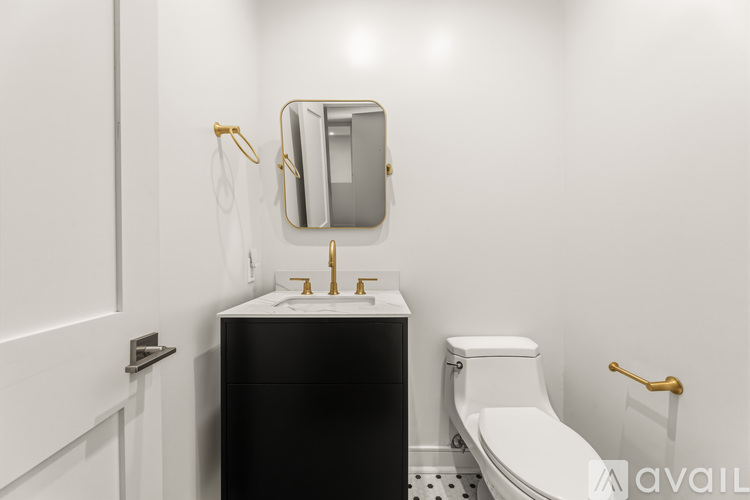 A bathroom with a black vanity and a white toilet.