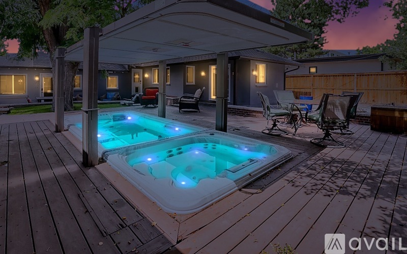 A hot tub sits on a deck in front of a house.
