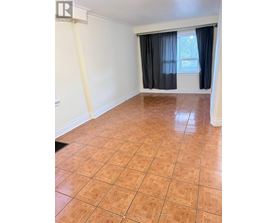 A room with tile flooring and a window with curtains.