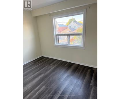 A room with a window showing a view of houses.