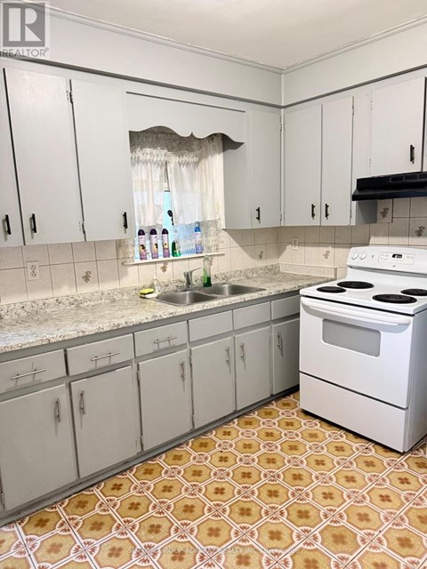 A kitchen with white cabinets and a patterned floor.