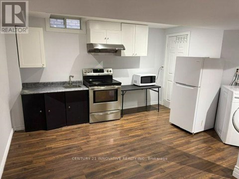 A kitchen with wooden floors and white appliances.