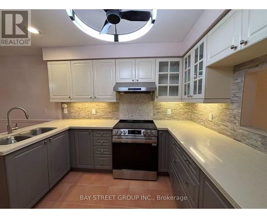 A kitchen with a stove top oven and a fan.
