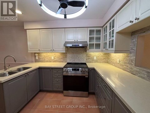 A kitchen with a stove top oven and a fan.