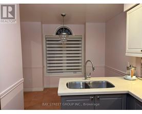 A kitchen with a sink and a window with blinds.