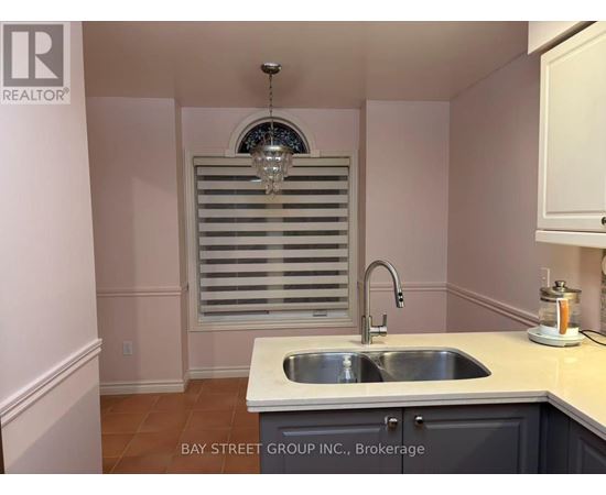 A kitchen with a sink and a window with blinds.