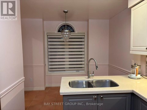 A kitchen with a sink and a window with blinds.