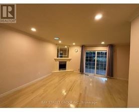 A spacious room with a fireplace and a window with curtains.