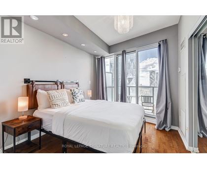 A bedroom with a large bed and a view of the outside.