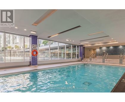 A swimming pool inside a building with a Realty sign.