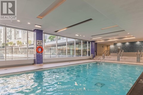 A swimming pool inside a building with a Realty sign.
