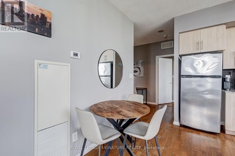 A modern kitchen with a wooden table and white chairs.