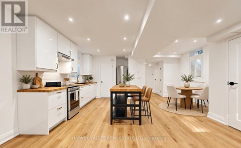 A modern kitchen with wooden floors and white walls.