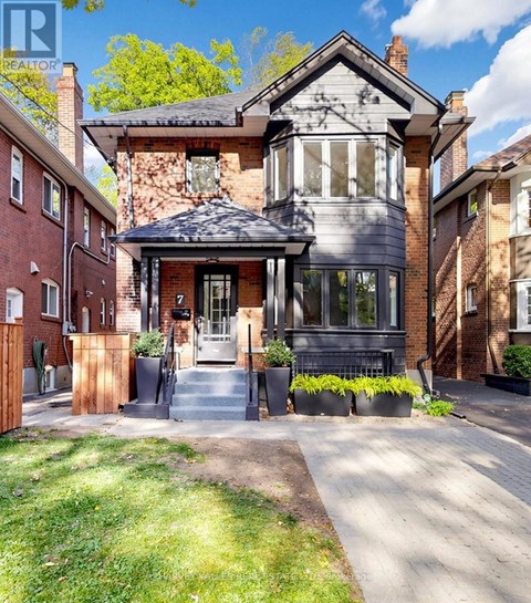 A house with a grey front yard and a black gate.