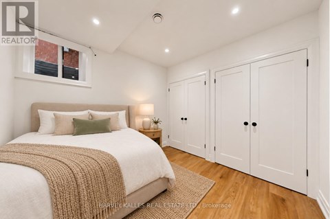 A bedroom with a bed, two nightstands, and a window.