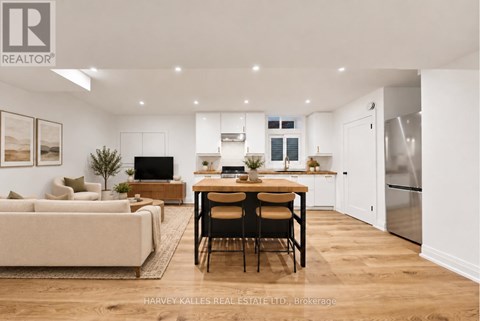 A well-lit, modern kitchen and living room with a dining table set for four.