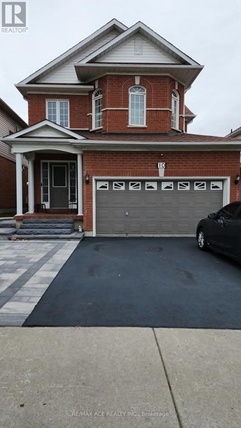 A brick house with a black car in front of it.