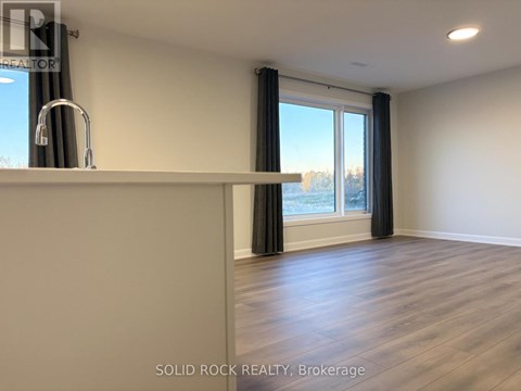 A room with a large window and a wooden floor.