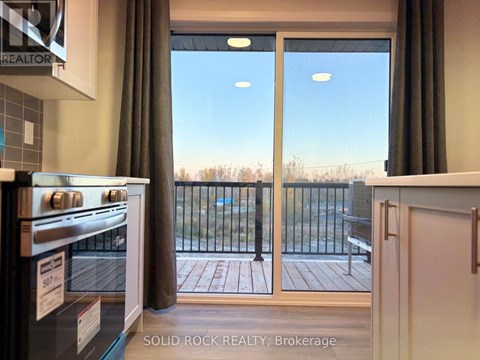 A kitchen with a stove top oven and a sliding glass door leading to a balcony.