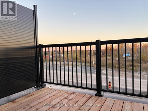 A black metal fence with a wooden deck in front of it.