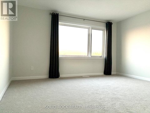 A room with a window and curtains, with the text "SOLID ROCK REALTY Brokerage" on the bottom.