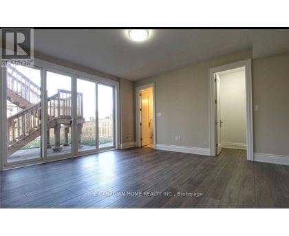 A room with a wooden floor and a sliding glass door leading to a deck.