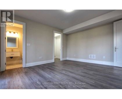 A room with wood flooring and a white door.