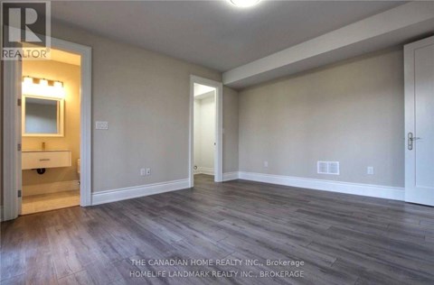 A room with wood flooring and a white door.