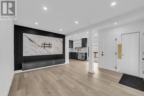 A modern living room with a large marble wall art and wooden flooring.