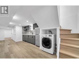 A modern kitchen with a washing machine built into the cabinetry.