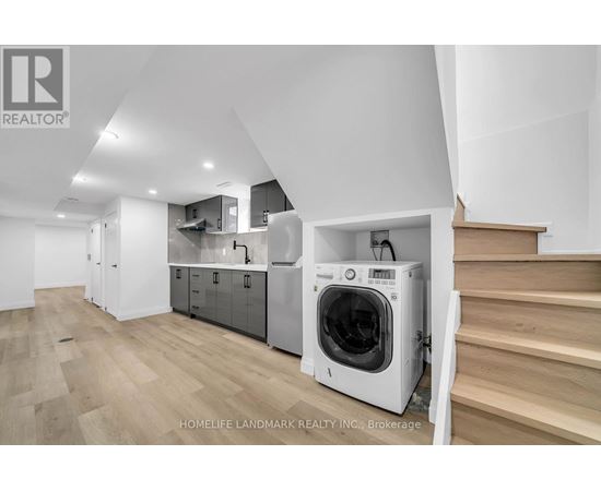 A modern kitchen with a washing machine built into the cabinetry.
