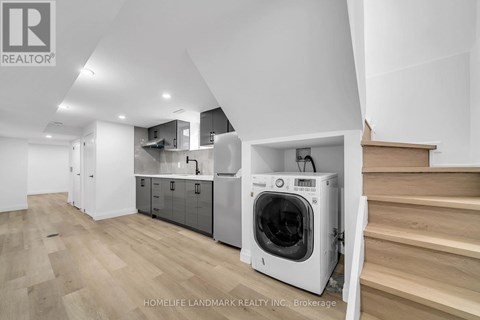 A modern kitchen with a washing machine built into the cabinetry.
