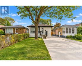 A tree in front of a house with a sign that says "HomeLife Landmark Realty, Inc. Brokerage".
